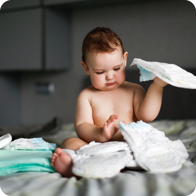 Baby mit Windeln auf dem Bett